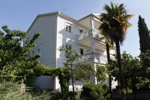 a white building with trees in front of it at Apartments with a parking space Icici, Opatija - 7761 in Ičići