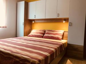 a bedroom with a large bed with white cabinets at Apartments with a parking space Icici, Opatija - 7761 in Ičići