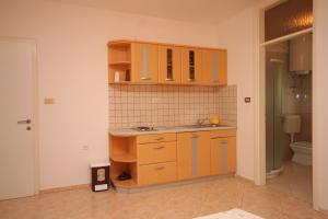 a kitchen with wooden cabinets and a sink at Apartments with a parking space Icici, Opatija - 7761 in Ičići +17 photos