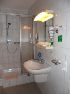 a bathroom with a sink and a shower at Waldpension Bielefeld in Bielefeld +13 photos