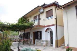 a house with a balcony and a patio at Apartments with a parking space Icici, Opatija - 7788 in Ičići