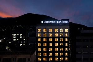a building with a sign on top of it at night at Seogwipo Hills Hotel in Seogwipo