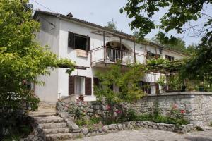 a large white house with a stone wall at Apartments with a parking space Icici, Opatija - 7763 in Ičići
