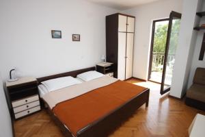 a bedroom with a large bed and a sliding glass door at Apartments with a parking space Icici, Opatija - 7763 in Ičići