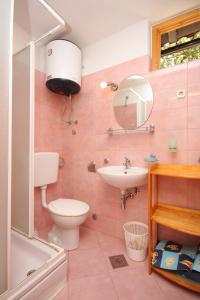 a bathroom with a toilet and a sink and a mirror at Apartments with a parking space Icici, Opatija - 7763 in Ičići