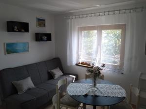 a living room with a couch and a table and a window at Apartments with a parking space Icici, Opatija - 7763 in Ičići