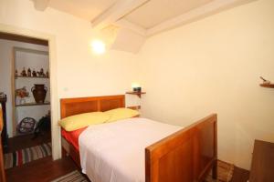 a bedroom with a bed with white sheets and yellow pillows at Holiday apartments Lastovo - 7790 in Lastovo