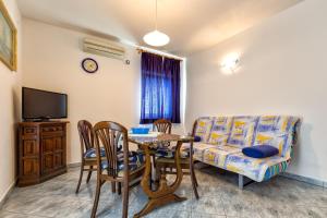 a living room with a table and a couch at Apartments with a parking space Mali Losinj (Losinj) - 8026 in Mali Lošinj