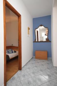 a bedroom with a mirror and a bed in it at Apartments with a parking space Mali Losinj (Losinj) - 8026 in Mali Lošinj