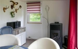 a living room with a heater and a red curtain at Lovely Home In Ot Goritz -wardow With Kitchen 