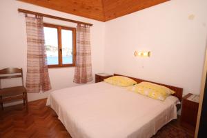 a bedroom with a bed with two pillows and a window at Apartments by the sea Mali Losinj (Losinj) - 8006 in Mali Lošinj