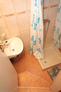 a bathroom with a sink and a shower curtain at Apartments by the sea Mali Losinj (Losinj) - 8006 in Mali Lošinj