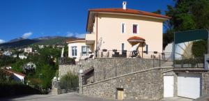 a white house on top of a stone wall at Apartments with a parking space Icici, Opatija - 7793 in Ičići