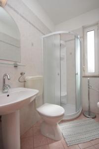 a bathroom with a shower and a toilet and a sink at Apartments with a parking space Icici, Opatija - 7793 in Ičići