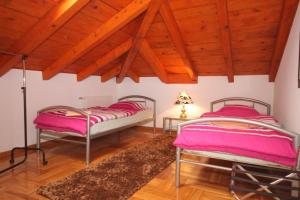 two beds in a room with wooden ceilings at Apartments with a parking space Icici, Opatija - 7793 in Ičići
