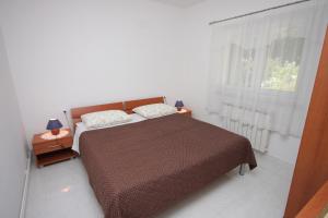 ein Schlafzimmer mit großem Bett und Fenster in der Unterkunft Apartments with a parking space Moscenicka Draga, Opatija - 7786 in Mošćenička Draga