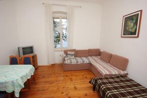 a living room with a couch and a tv at Family friendly seaside apartments Moscenicka Draga, Opatija - 7798 in Mošćenička Draga