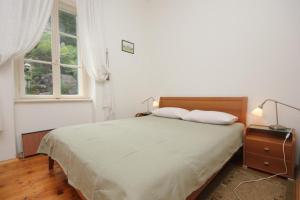 a bedroom with a bed with two pillows and a window at Family friendly seaside apartments Moscenicka Draga, Opatija - 7798 in Mošćenička Draga