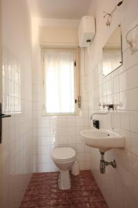 Baño blanco con aseo y lavamanos en Apartments with a parking space Lovran, Opatija - 7807 en Lovran
