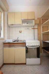 a small kitchen with a sink and a stove at Apartments with a parking space Lovran, Opatija - 7807 in Lovran