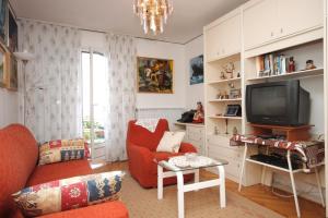 a living room with a red couch and a tv at Apartments with a parking space Icici, Opatija - 7822 in Ičići