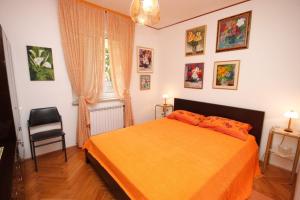a bedroom with a orange bed and a chair at Apartments with a parking space Icici, Opatija - 7822 in Ičići