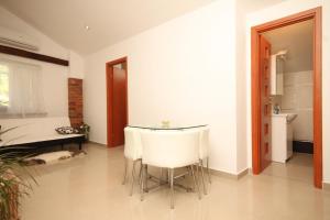 a dining room with a table and white chairs at Apartments with a parking space Opatija - 7891 in Opatija