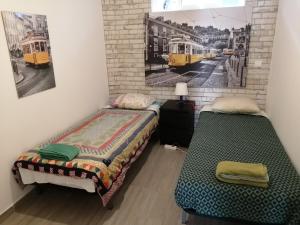 two beds in a room with two pictures on the wall at Paradise Space in Lisbon