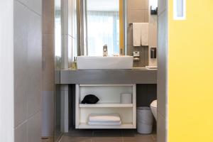 a bathroom with a sink and a counter with a mirror at Seogwipo Hills Hotel in Seogwipo +22 photos