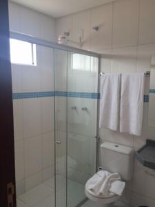 a bathroom with a glass shower with a toilet at Pousada Santo André - O Apóstolo in Juazeiro do Norte