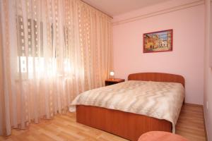 a bedroom with a bed and a window with curtains at Apartments with a parking space Opatija - 7857 in Opatija