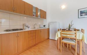 a kitchen with a table and a refrigerator at Apartments with a parking space Nerezine, Losinj - 7961 in Nerezine