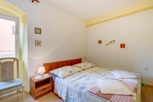 ein Schlafzimmer mit einem Bett, einem Stuhl und einem Fenster in der Unterkunft Apartments with a parking space Mali Losinj (Losinj) - 8053 in Mali Lošinj