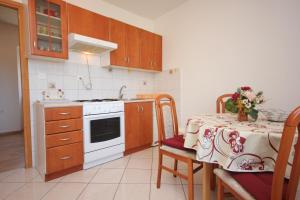 eine Küche mit einem Tisch und einem weißen Herd mit Backofen in der Unterkunft Apartments with a parking space Mali Losinj (Losinj) - 8053 in Mali Lošinj