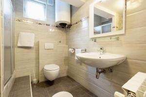 łazienka z umywalką, toaletą i lustrem w obiekcie Apartments with a parking space Opatija - 7861 w mieście Opatija