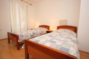 A bed or beds in a room at Apartments with a parking space Mali Losinj (Losinj) - 7944
