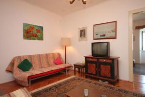 ein Wohnzimmer mit einem Sofa und einem TV in der Unterkunft Apartments by the sea Opatija - Volosko, Opatija - 7911 in Opatija