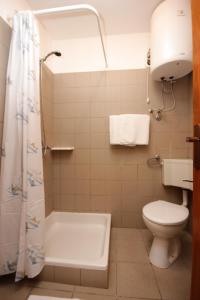 a bathroom with a tub and a toilet and a shower at Apartments with a parking space Mali Losinj (Losinj) - 7940 in Mali Lošinj