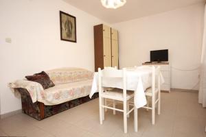 a bedroom with a bed and a table and chairs at Apartments with a parking space Mali Losinj (Losinj) - 7940 in Mali Lošinj