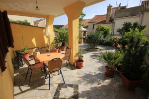 a patio with a table and chairs and potted plants at Apartments with a parking space Mali Losinj (Losinj) - 7940 in Mali Lošinj