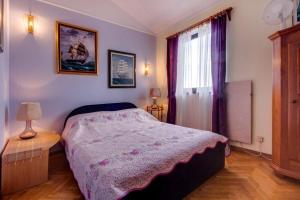a bedroom with a bed and a window at Apartments with a parking space Mali Losinj (Losinj) - 8000 in Mali Lošinj