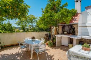 a patio with a table and a fireplace at Apartments with a parking space Mali Losinj (Losinj) - 8067 in Mali Lošinj