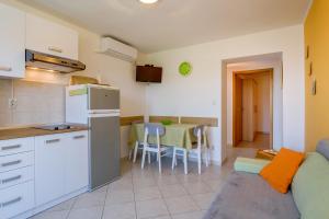a kitchen and living room with a couch and a table at Apartments with a parking space Mali Losinj (Losinj) - 8067 in Mali Lošinj