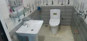 a bathroom with a white toilet and a sink at Green Hills Homestay in Ha Lãm