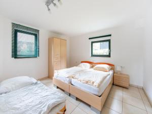 a bedroom with two beds and two windows at Comfortable apartment in Eisfeld with bicycle storage in Eisfeld