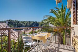 een tafel en stoelen op het balkon van een huis bij Apartments by the sea Artatore, Losinj - 7934 in Čunski