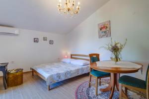 sypialnia z łóżkiem, stołem i krzesłami w obiekcie Apartment Mali Losinj 7942a w miejscowości Mali Lošinj