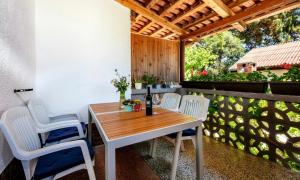 een houten tafel en stoelen op een patio bij Apartments by the sea Artatore, Losinj - 8020 in Čunski