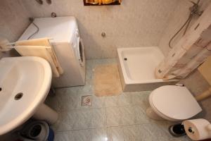 La salle de bains est pourvue de toilettes blanches et d'un lavabo. dans l'établissement Apartments with a parking space Veli Losinj, Losinj - 8029, à Veli Lošinj