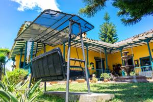 a playground in front of a yellow house at FINCA COCUYAL...todo un pesebre VIVO! in Rionegro